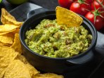 Тарілка гуакамоле з чипсами та помідорами