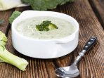 Крем-суп з броколі у білій мисці на дерев'яному столі