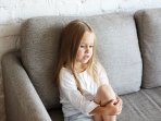 Дитина сидить на дивані