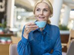 Жінка п'є каву