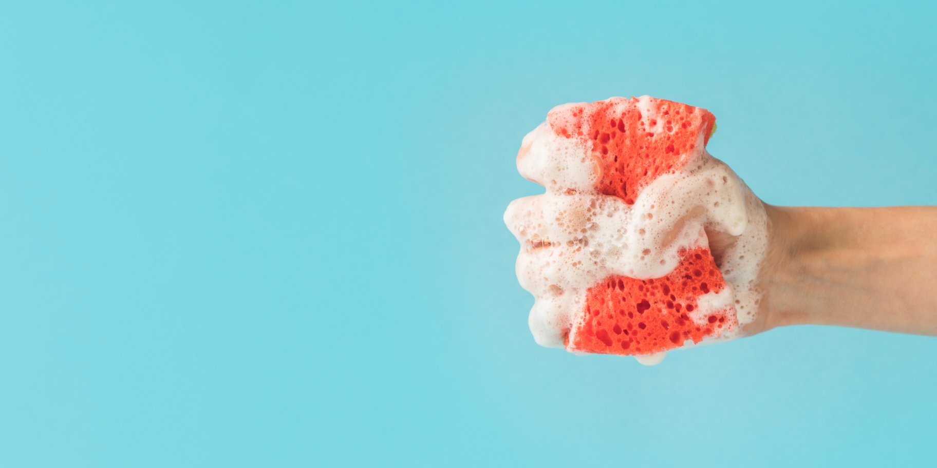 Рука з кухонною губкою