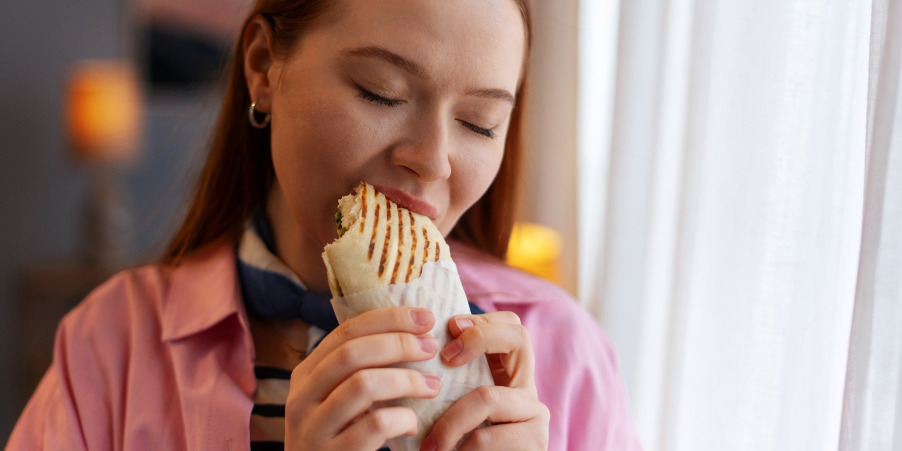 Жінка їсть фастфуд