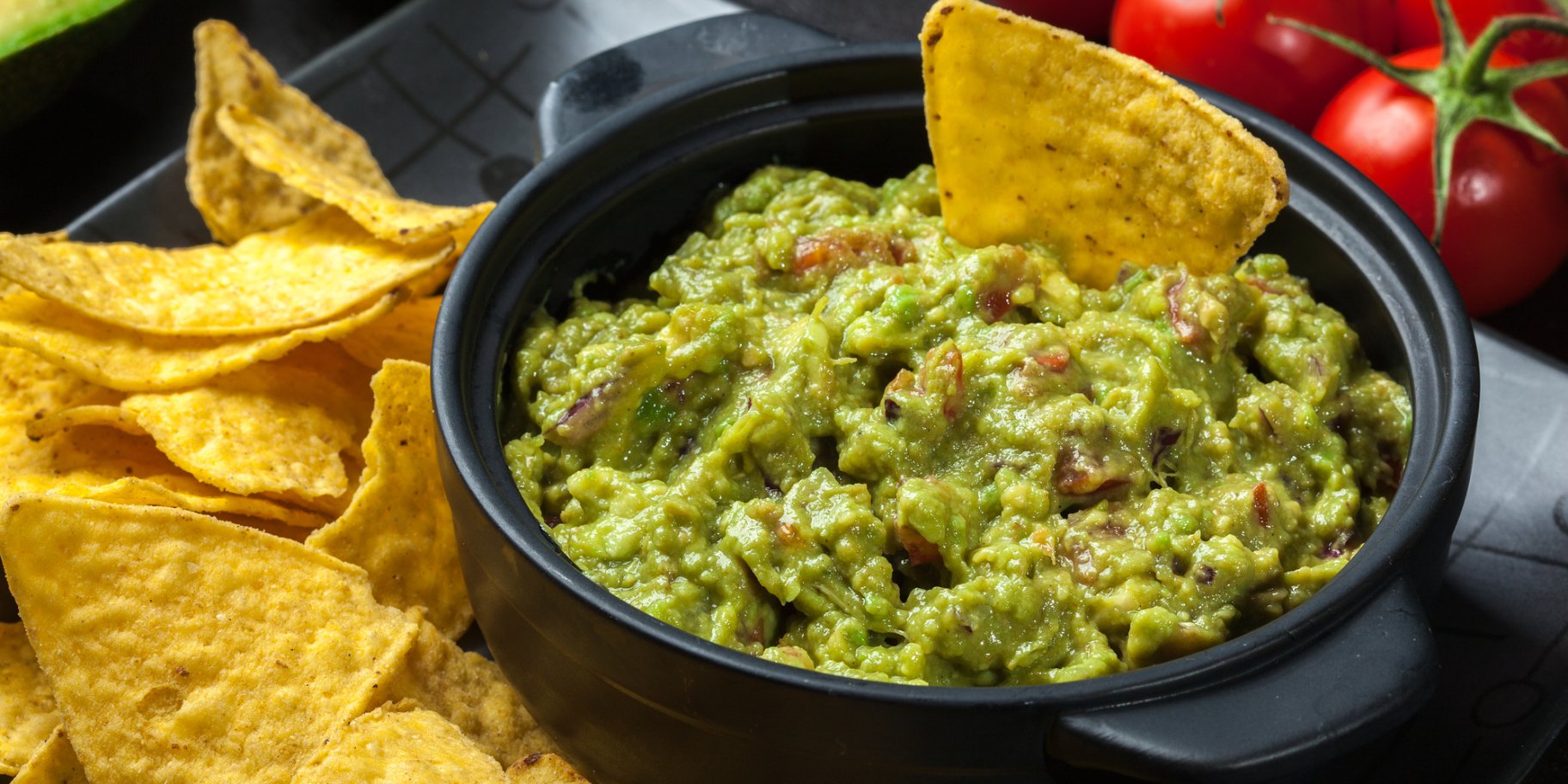 Тарілка гуакамоле з чипсами та помідорами