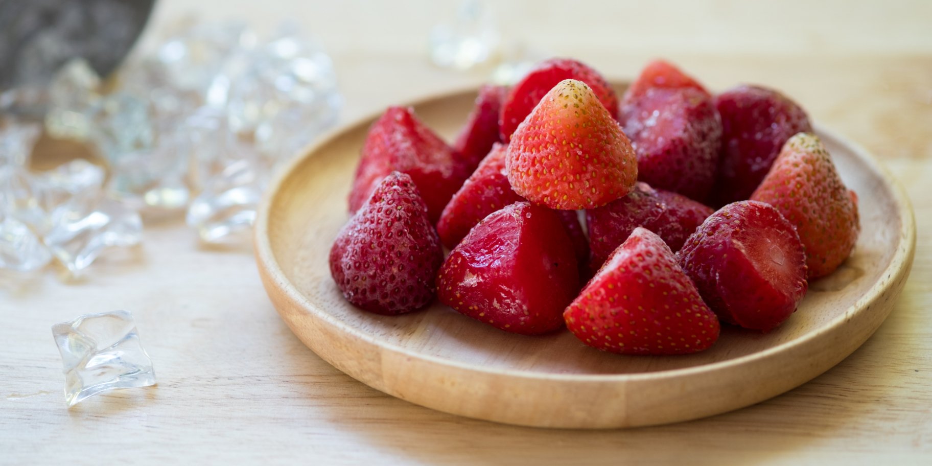 Заморожена полуниця в дерев'яній тарілці