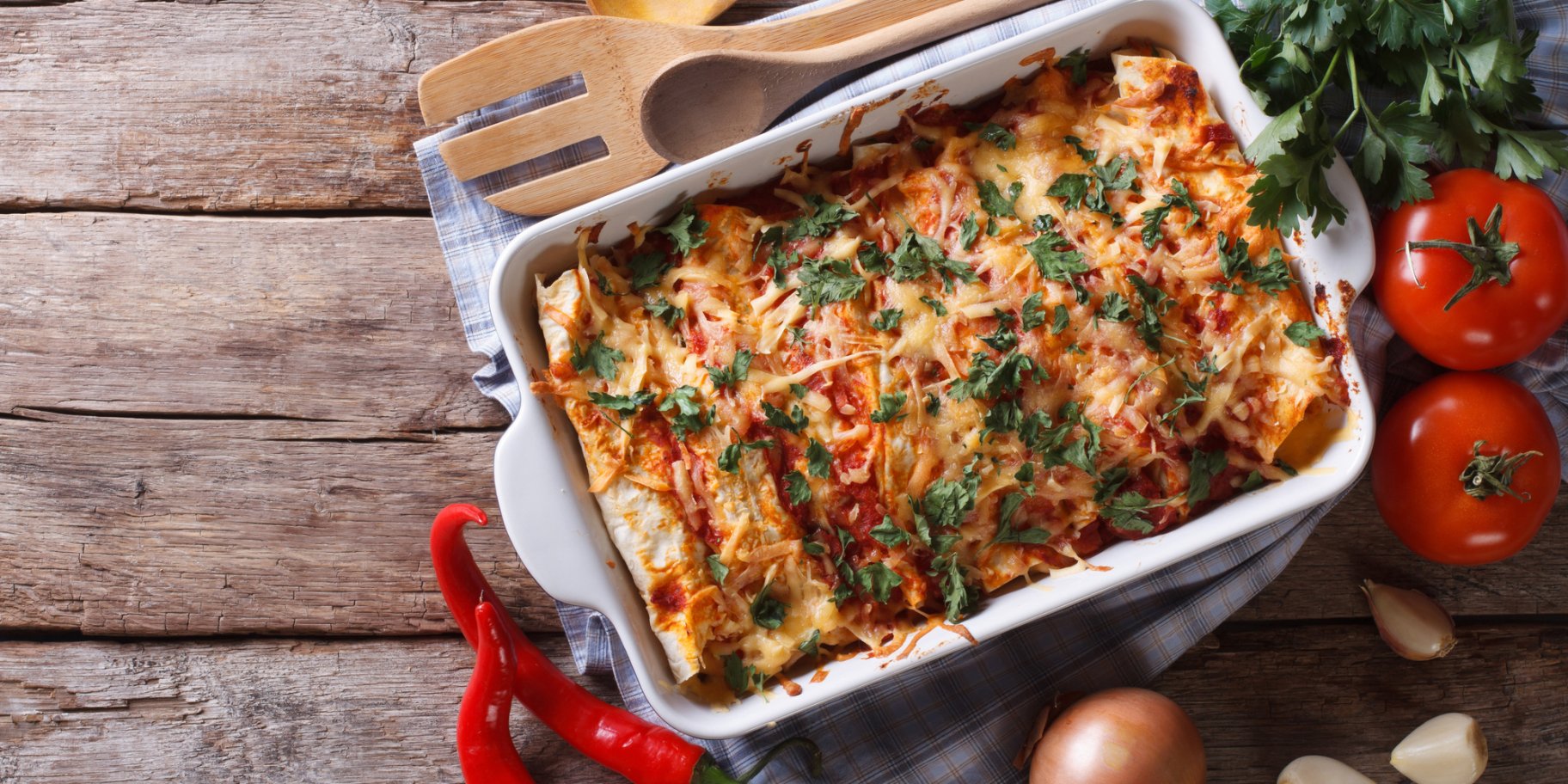 Запіканка з картоплею та куркою на фоні столу з овочами