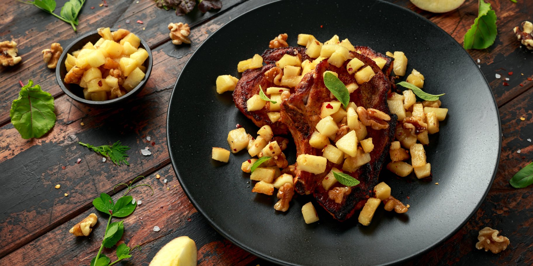 Свиная отбивная с яблоками в черной тарелке