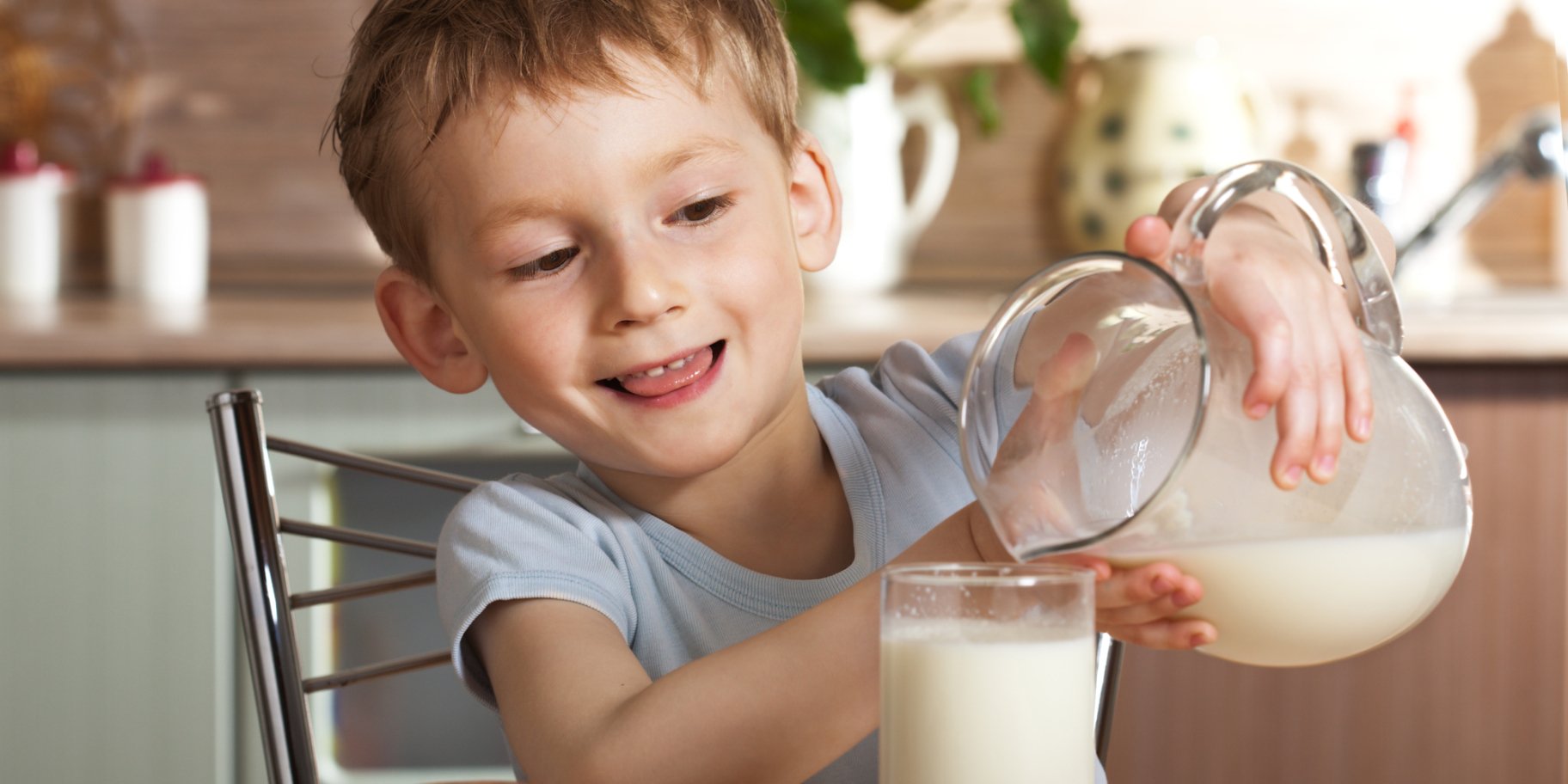 Дитина наливає молоко в склянку