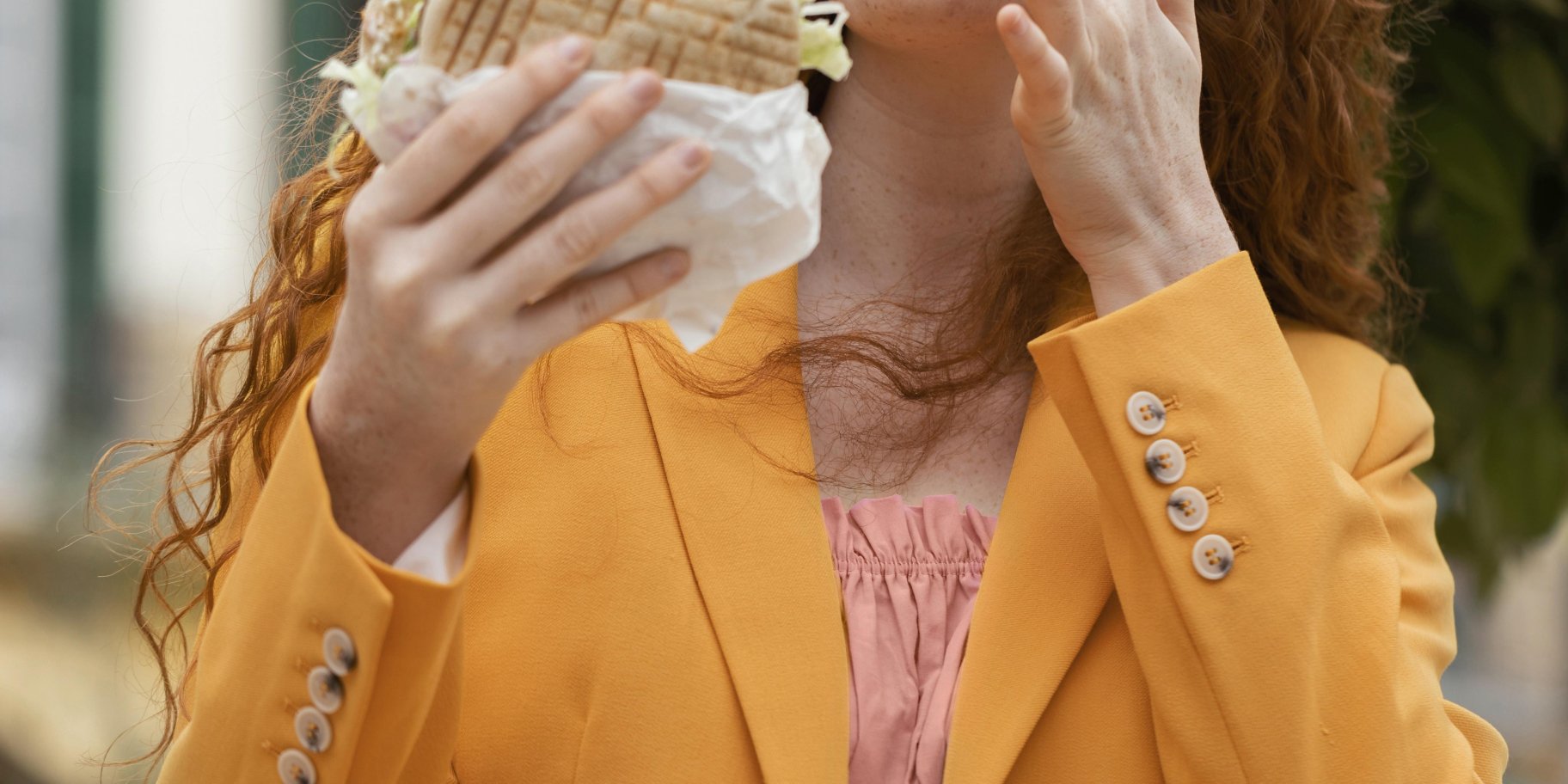 Дівчина їсть вуличну їжу