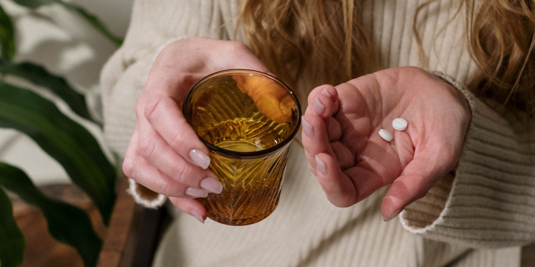 Жінка п'є піґулки від болю