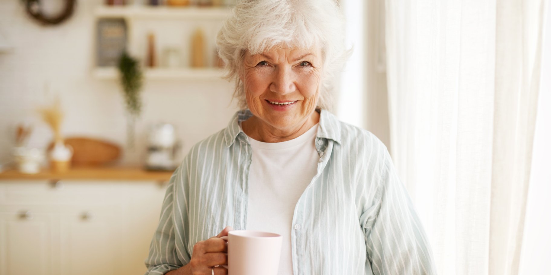 Літня жінка п'є чай