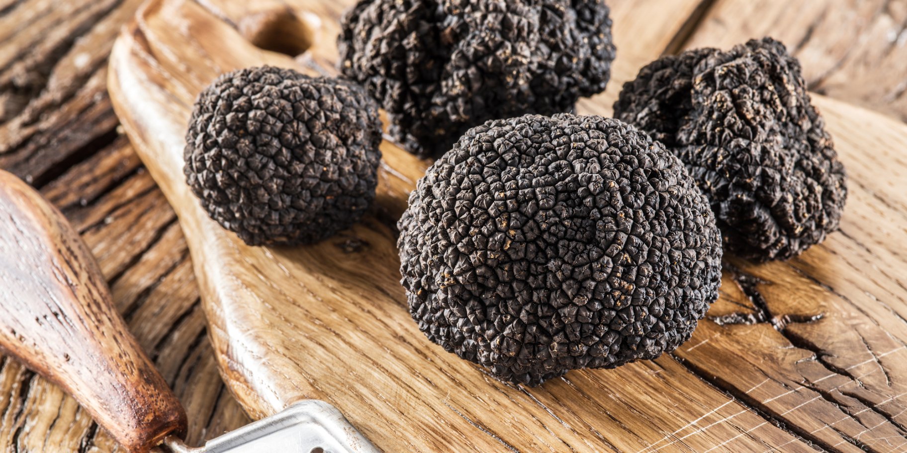 Чотири чорні трюфелі на дерев'яному столі