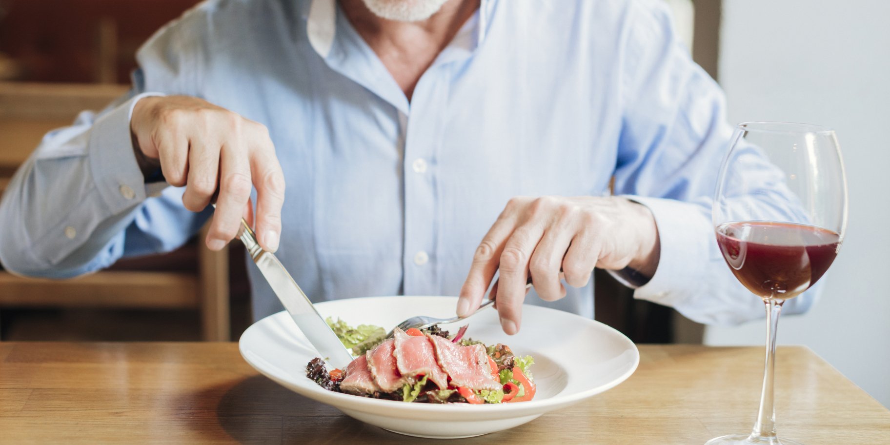 Чоловік їсть м'ясо