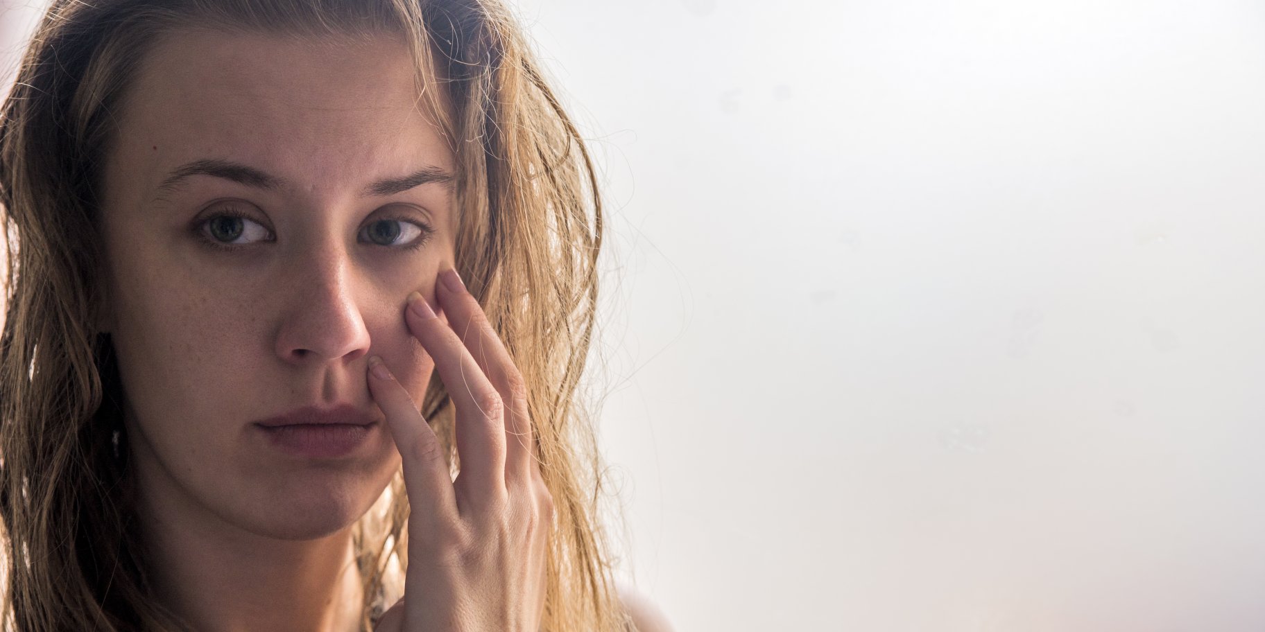 Женщина рассматривает свое лицо