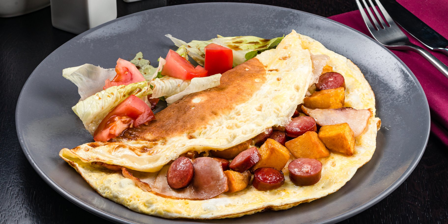 Омлет-сендвіч із сосисками, шинкою і картоплею під сиром