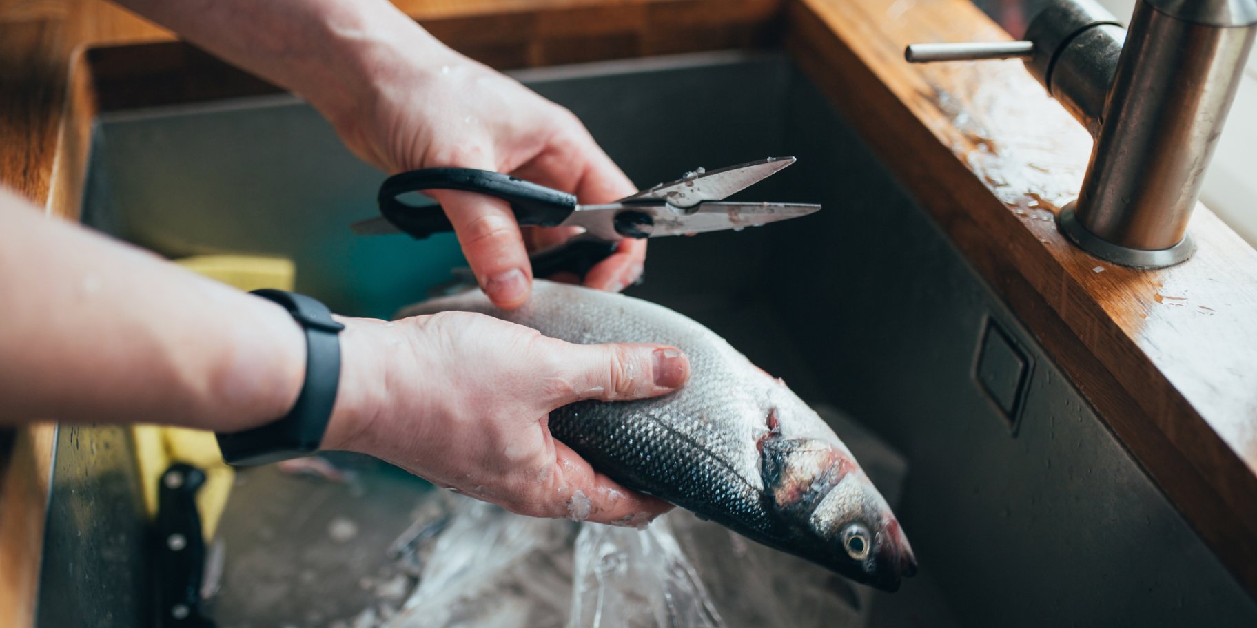 Людина чистить рибу