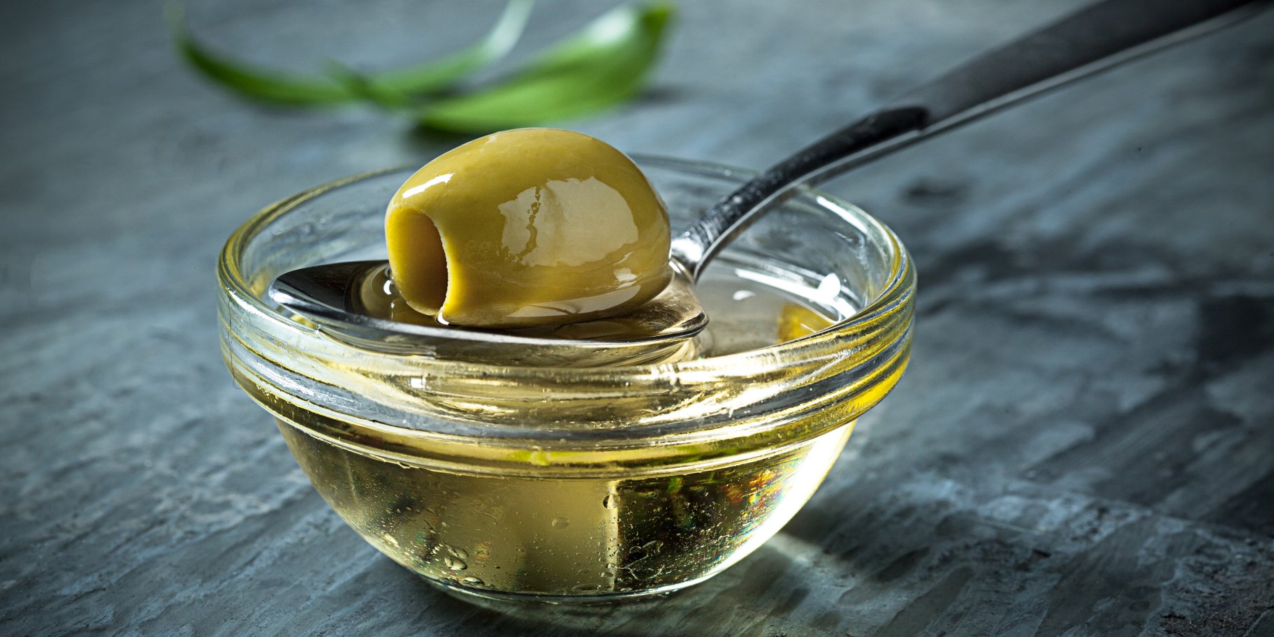 Оливковое масло и зеленая оливка