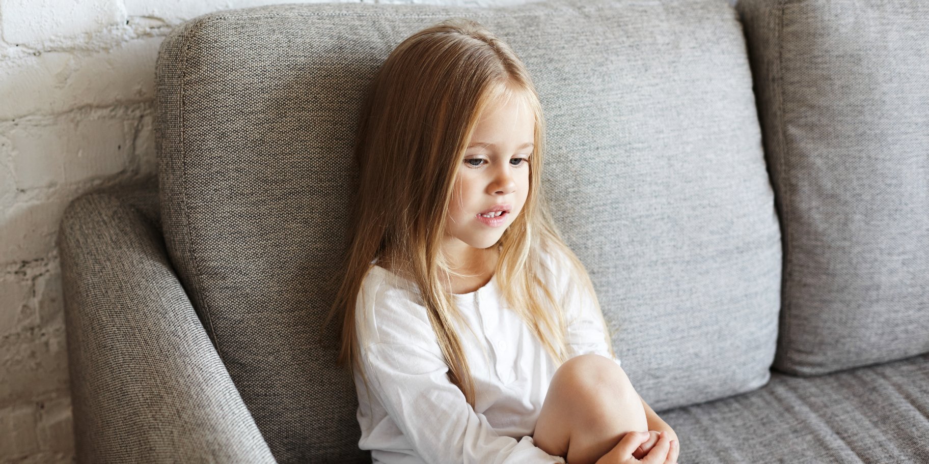 Дитина сидить на дивані
