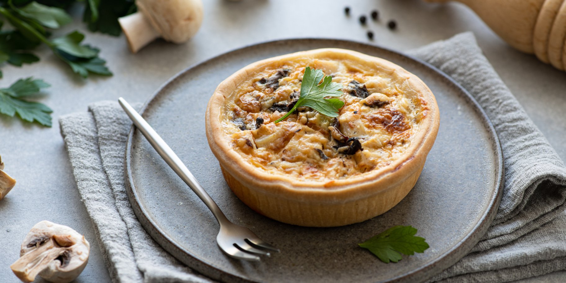 Киш с грибами и курицей на серой тарелке