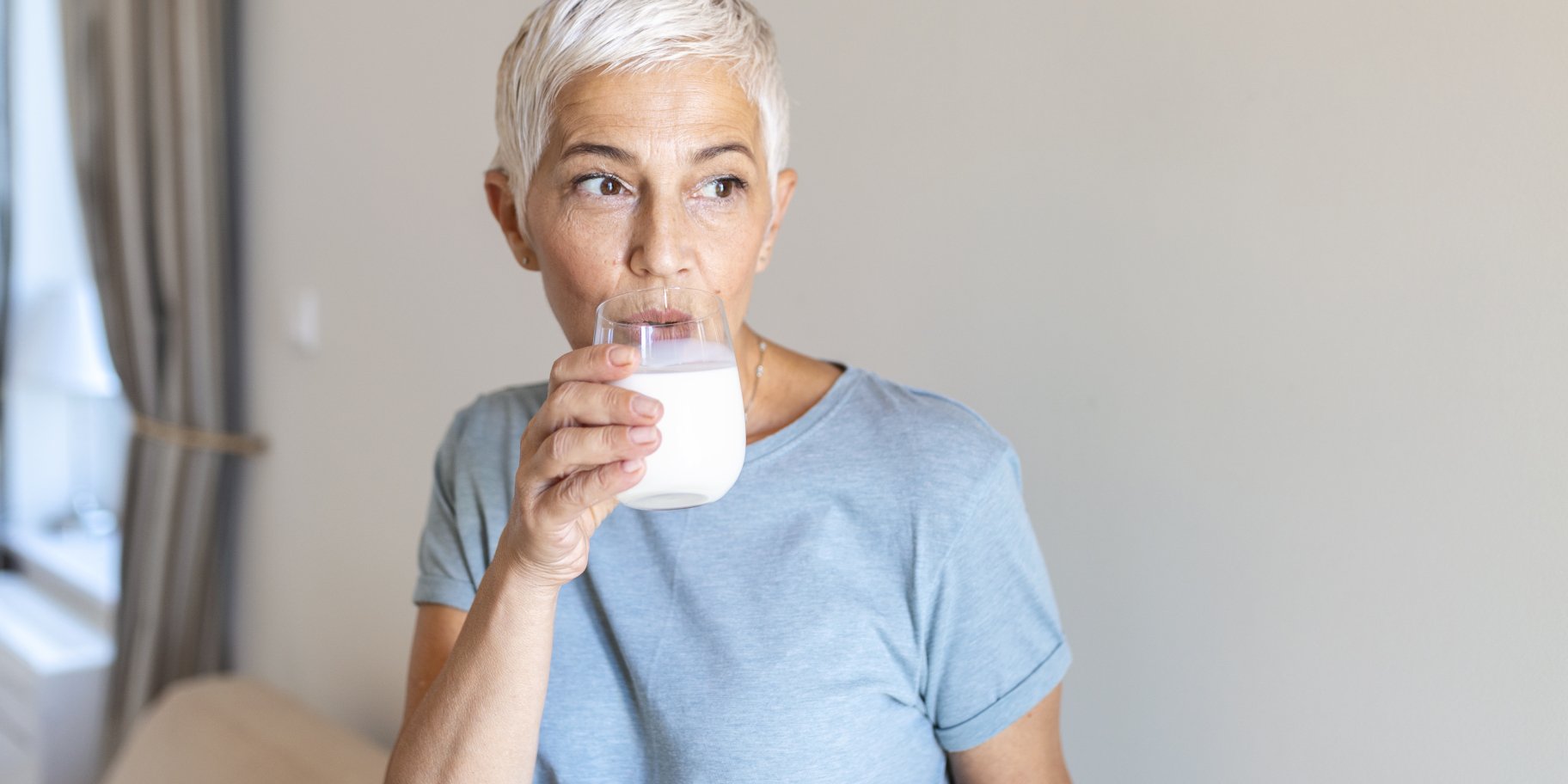 Жінка п'є йогурт