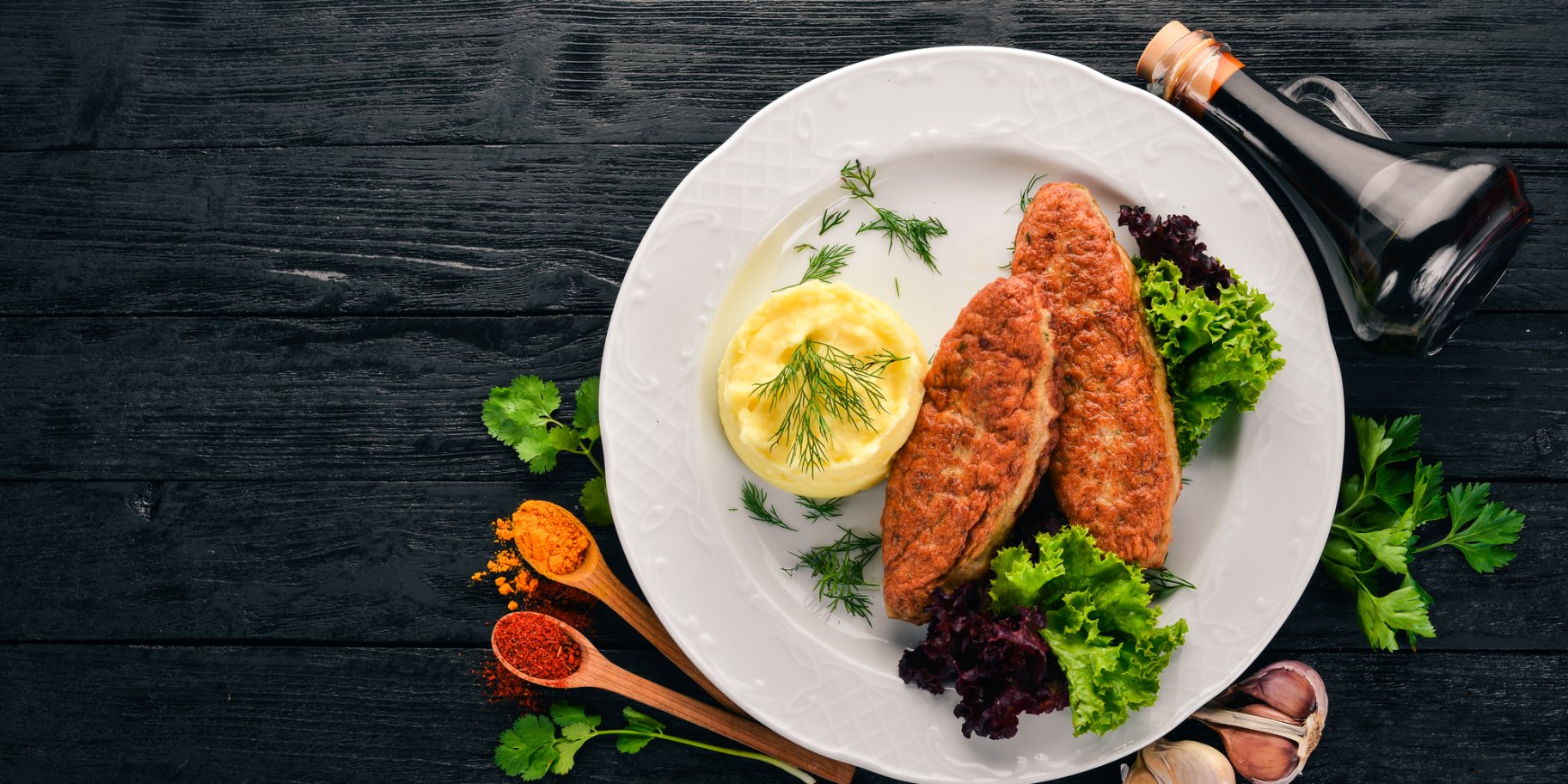 Курячі котлети з пюре із капусти на темному столі зі спеціями