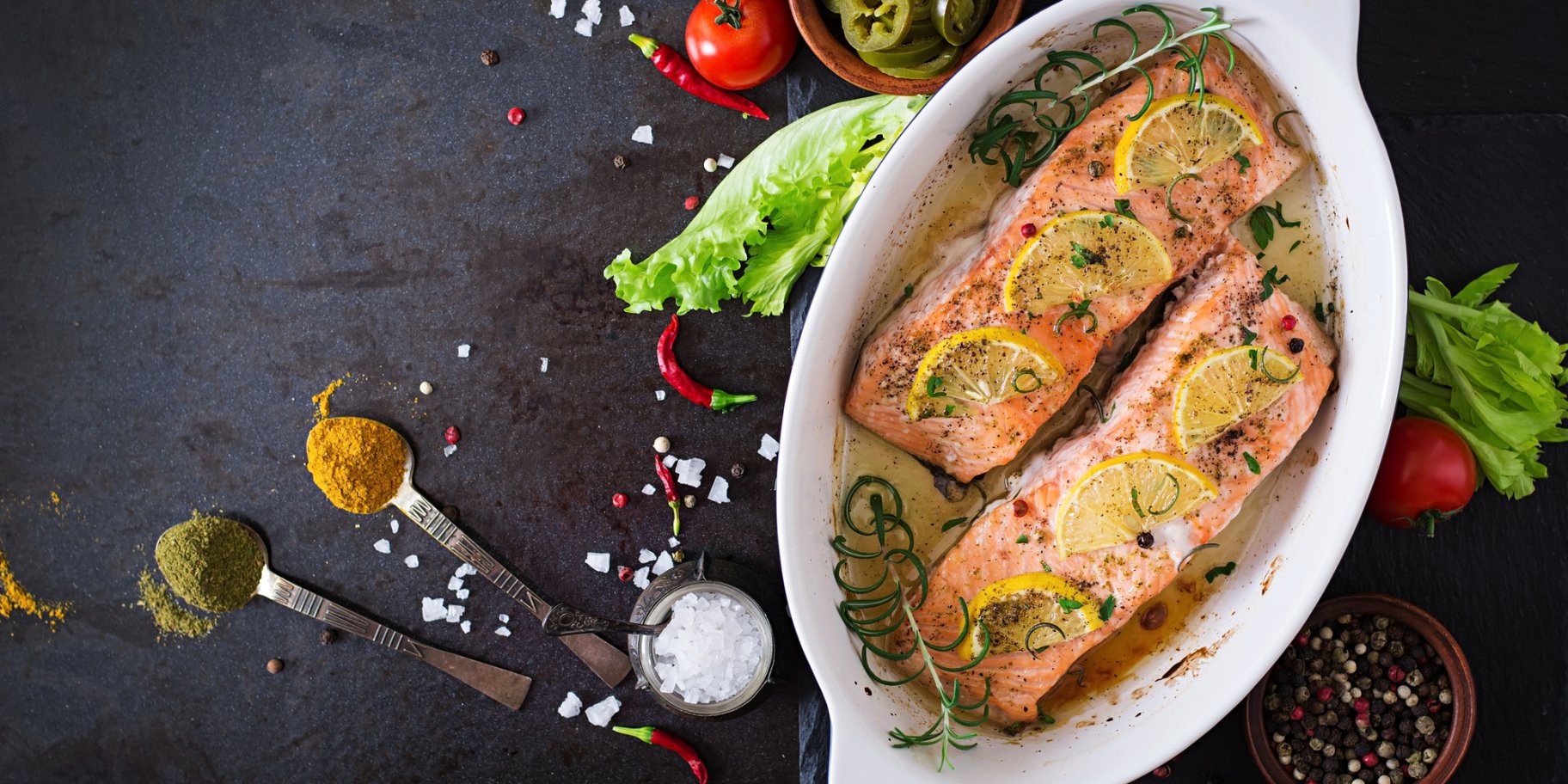 Запечений лосось з лимоном та овочами зі спеціями на чорному столі