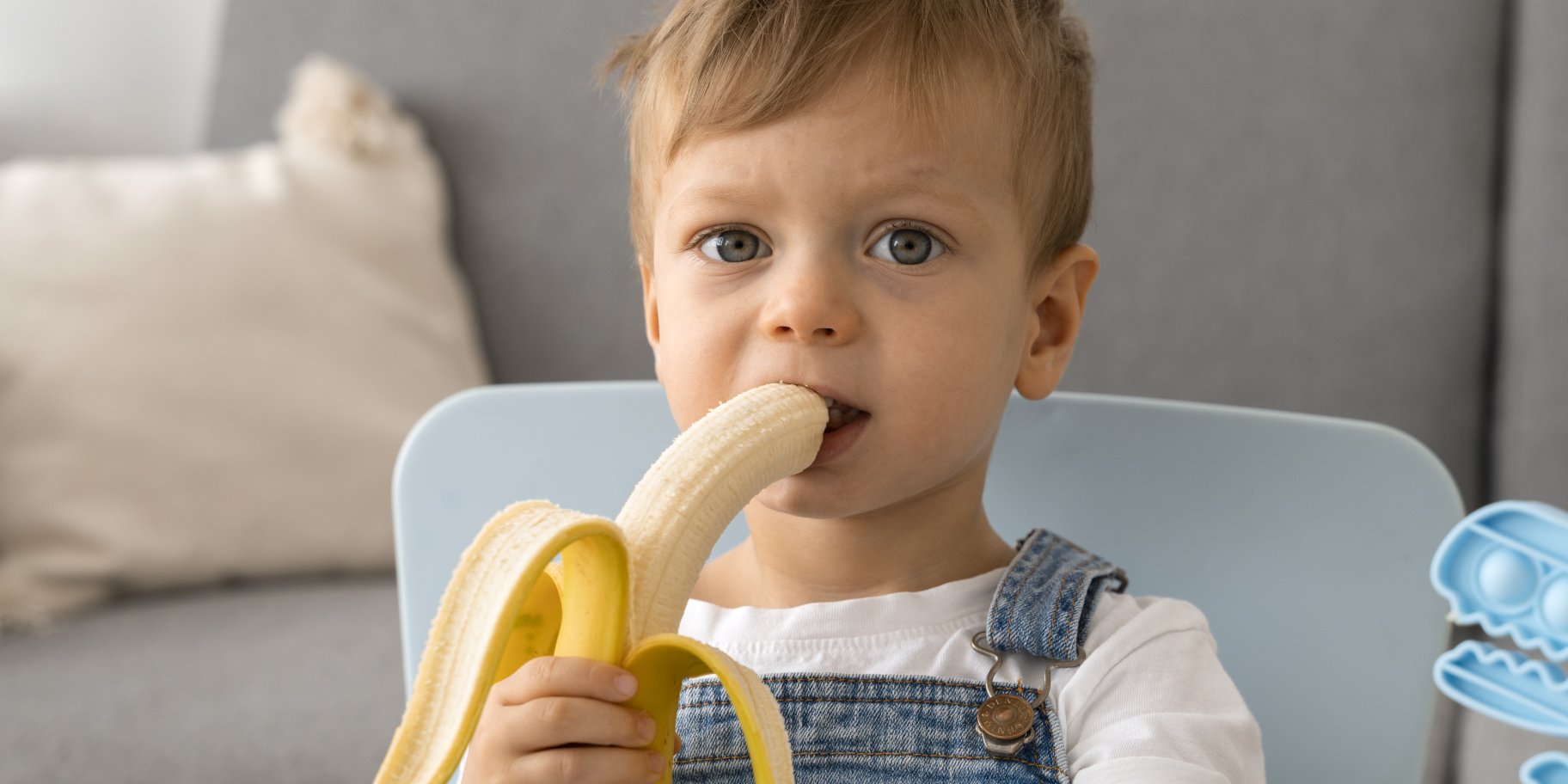 Хлопчик їсть фрукт