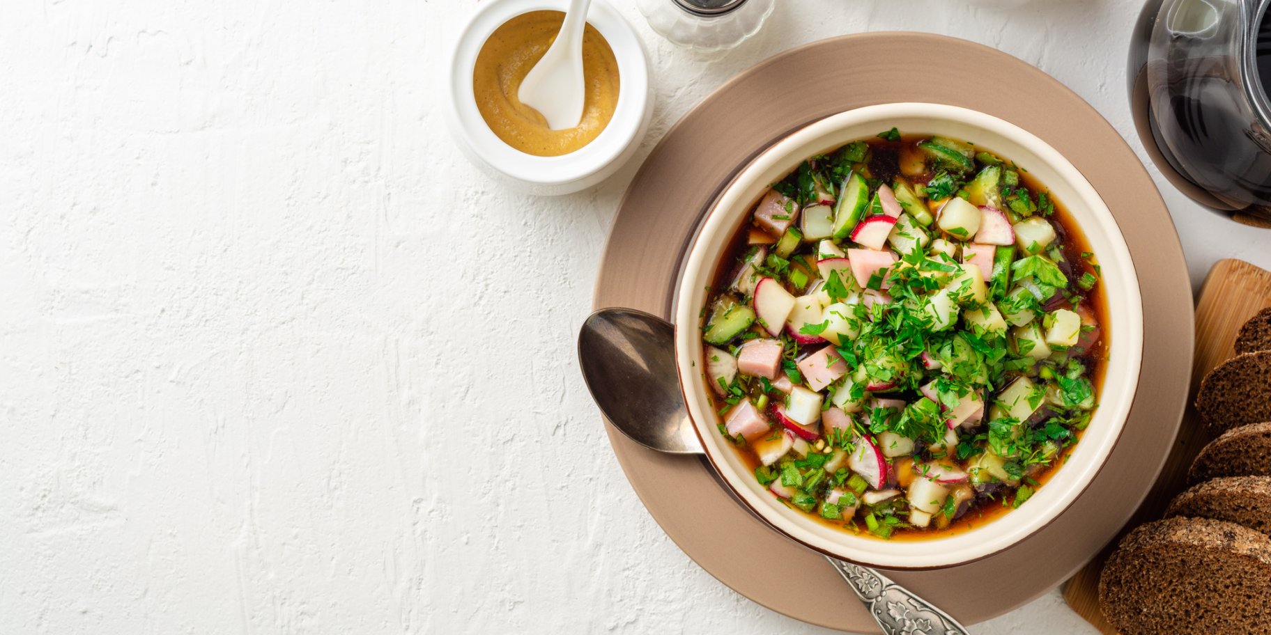 Холодний суп з кількою в томаті на тарілці на білому фоні