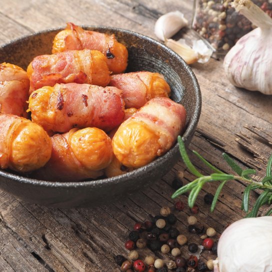 Фаршировані сардельки в беконі.