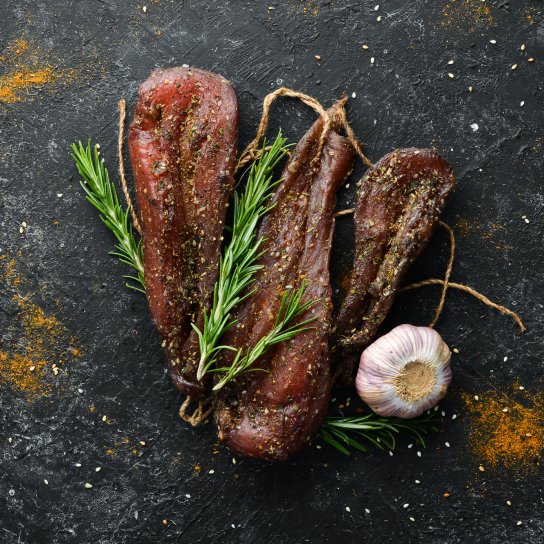 Курячі грудки сушені на чорному фоні із часником