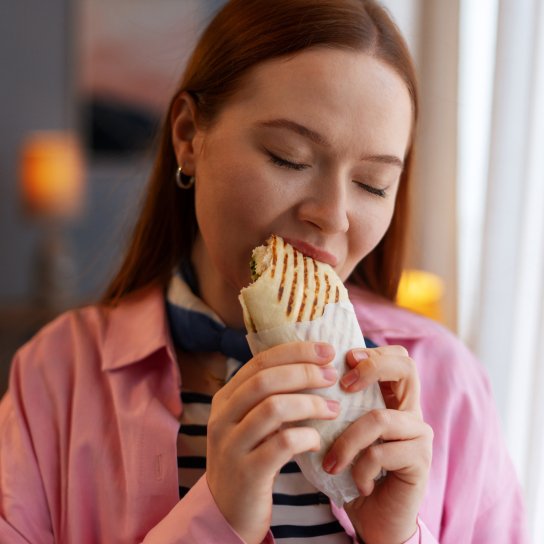 Жінка їсть фастфуд