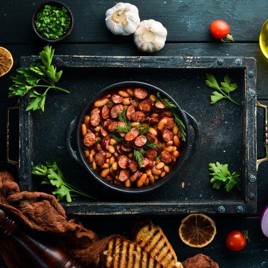 Квасоля з ковбасками на сковороді