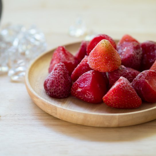 Заморожена полуниця в дерев'яній тарілці