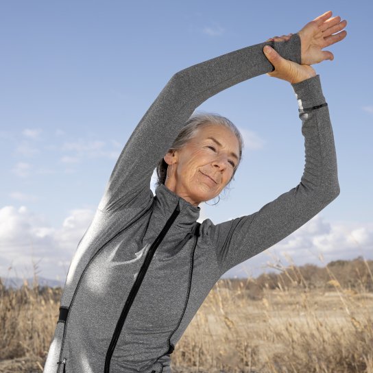 Літня жінка робить розтяжку