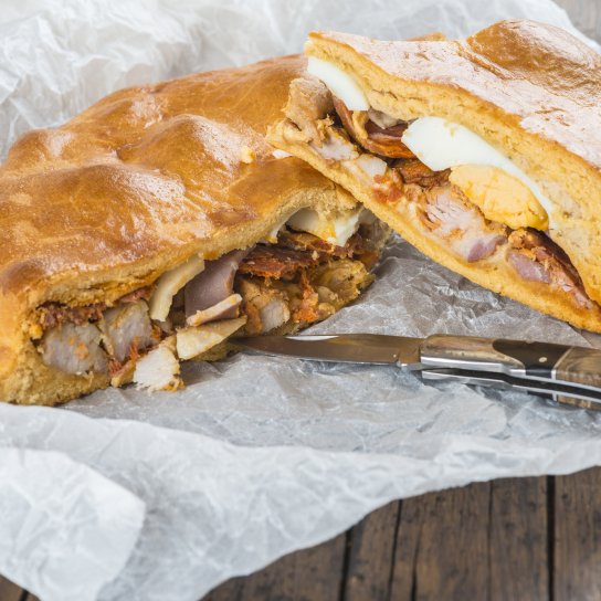 Пиріг хорназо з яйцем на пергаментному папері з ножем