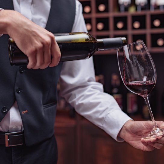 Сомельє розливає вино