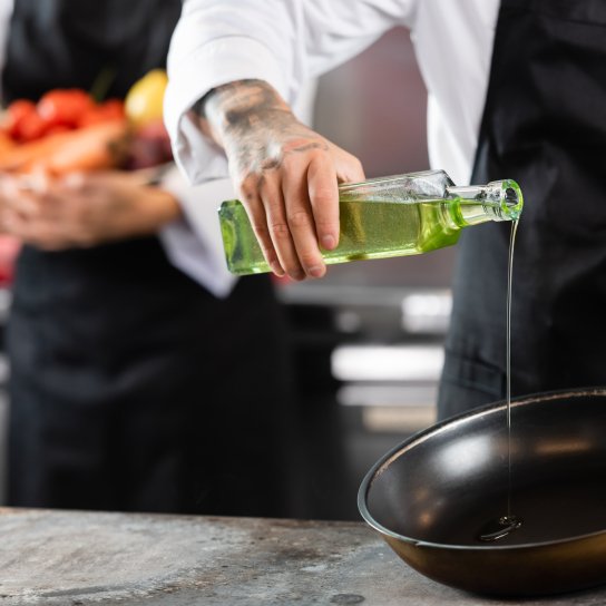Человек наливает масло