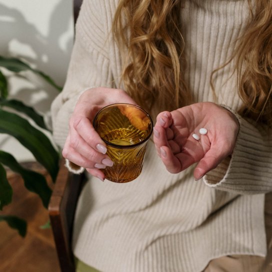 Женщина принимает таблетки от боли