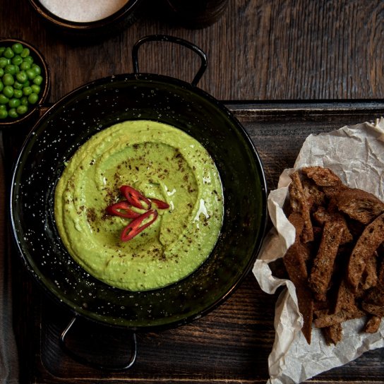 Салат з хумусом на чорній тарілці