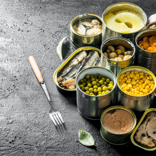 Банки з різноманітними консервами на столі