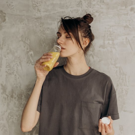 Дівчина п'є напій