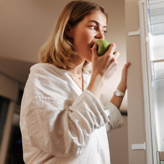 Жінка їсть яблуко