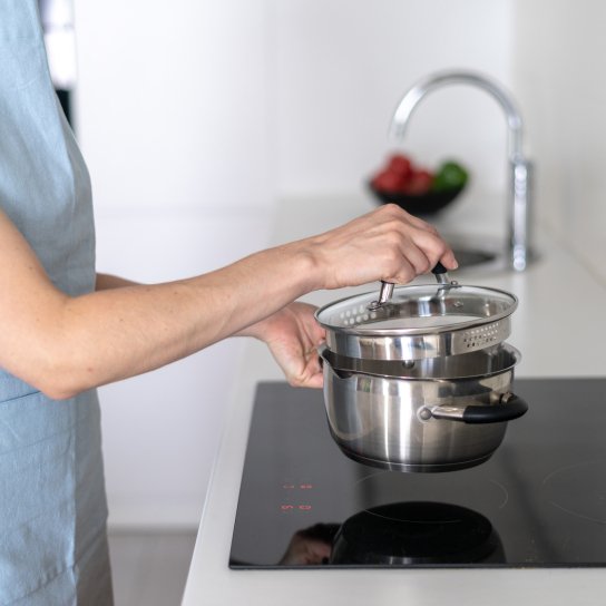 Жінка тримає каструлю з кришкою