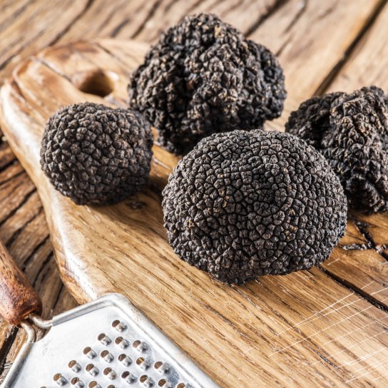 Чотири чорні трюфелі на дерев'яному столі