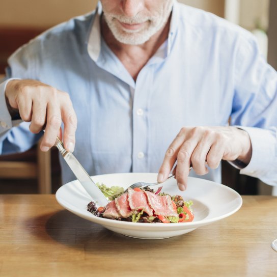 Чоловік їсть м'ясо