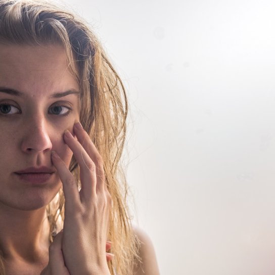 Жінка роздивляється своє обличчя