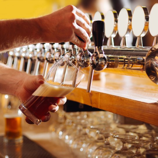 Бармен наливає ель у келих