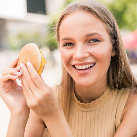 Жінка їсть фастфуд
