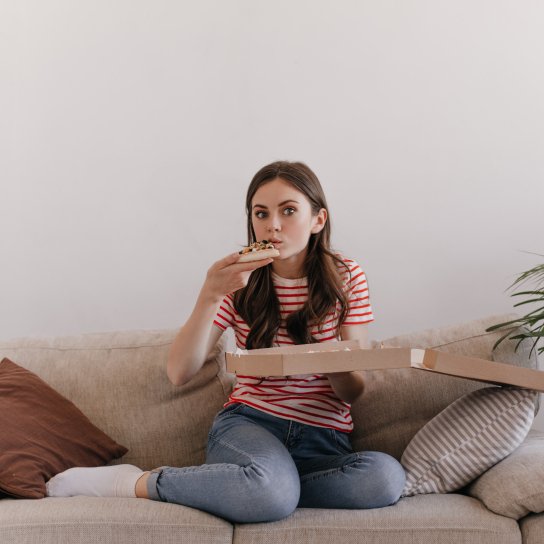 Дівчина їсть піцу