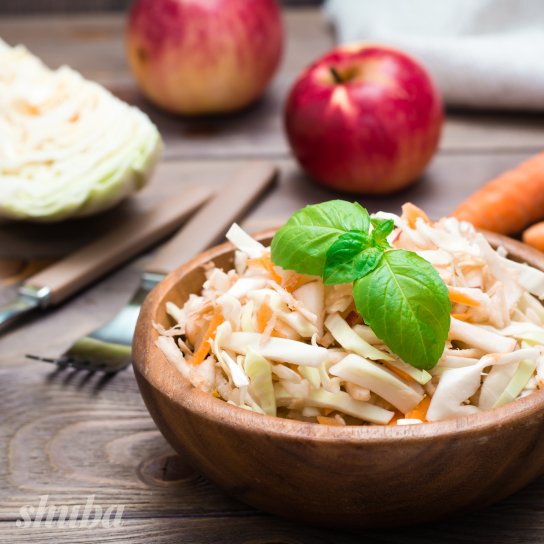 Салат з капустою, яблуком та морквою в тарілці