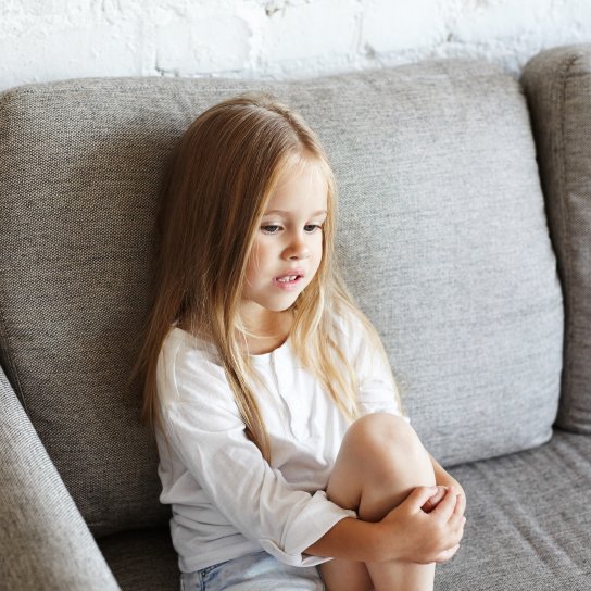 Дитина сидить на дивані